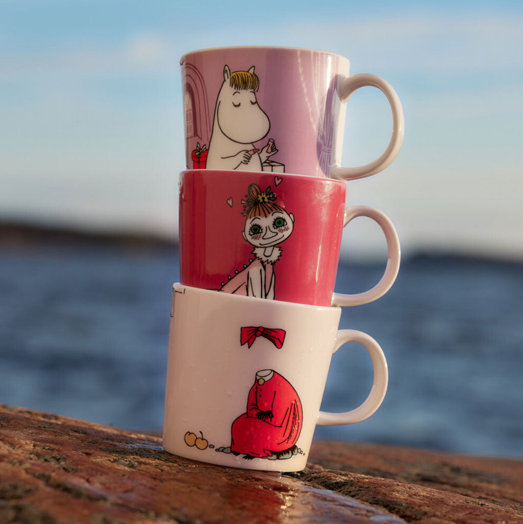 An Image of three Moomin Arabia Mugs on a rock by the sea